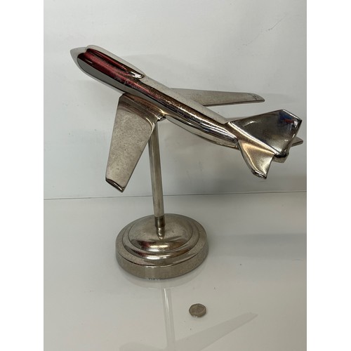 179 - A stylised chrome plated aviation desk piece, a large jet age model of plane with a raised cockpit s... 