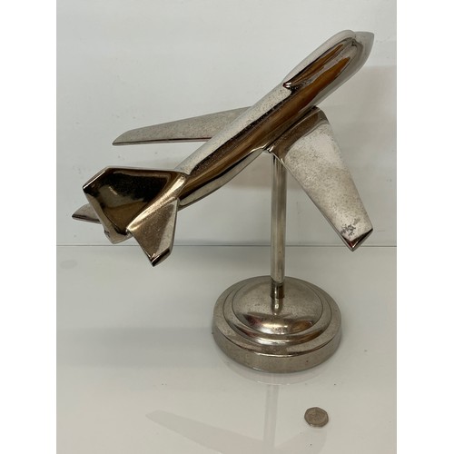 179 - A stylised chrome plated aviation desk piece, a large jet age model of plane with a raised cockpit s... 