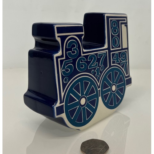 9 - Carlton ware studio pottery money box in the form of a train. 13 cm high x 15 cm long.

This lot is ... 