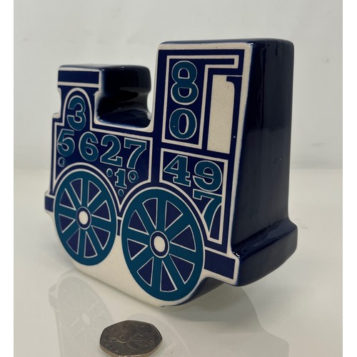 9 - Carlton ware studio pottery money box in the form of a train. 13 cm high x 15 cm long.

This lot is ... 