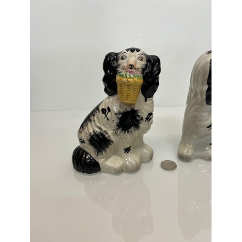 14 - A pair of Staffordshire wally dogs each holding a basket of flowers.

This lot is available for in-h... 