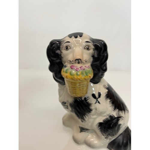 14 - A pair of Staffordshire wally dogs each holding a basket of flowers.

This lot is available for in-h... 