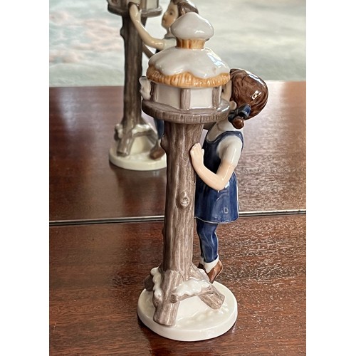 124 - Royal Copenhagen ceramic figure of a girl tending  a bird box.

This lot is available for in-house s... 