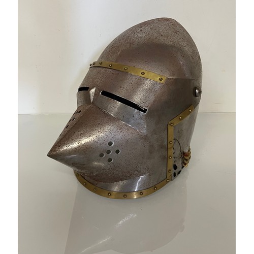 105 - A Medieval design knights helmet with weighted brass trimmings on a steel shell. 26 cm tall x 30 cm ... 