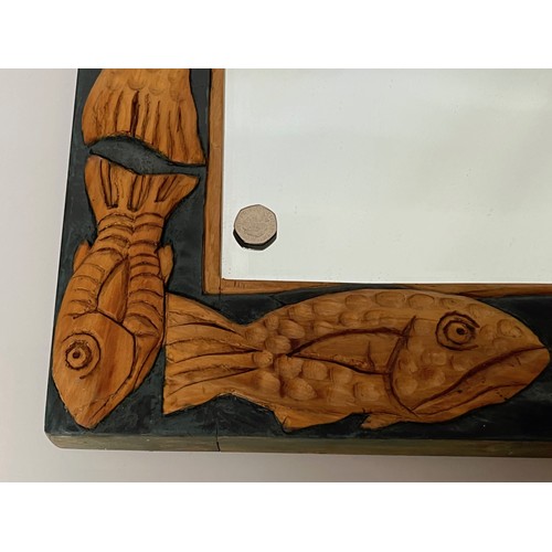 219 - Contempery hand carved wooden framed mirror, decorated with fish. 63 cm x 56 cm x 5 cm.

This lot is... 