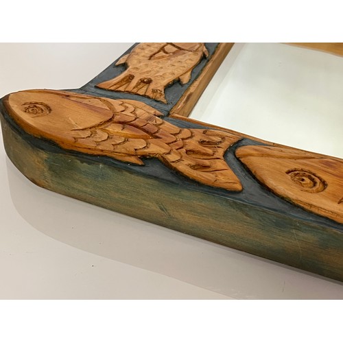 219 - Contempery hand carved wooden framed mirror, decorated with fish. 63 cm x 56 cm x 5 cm.

This lot is... 