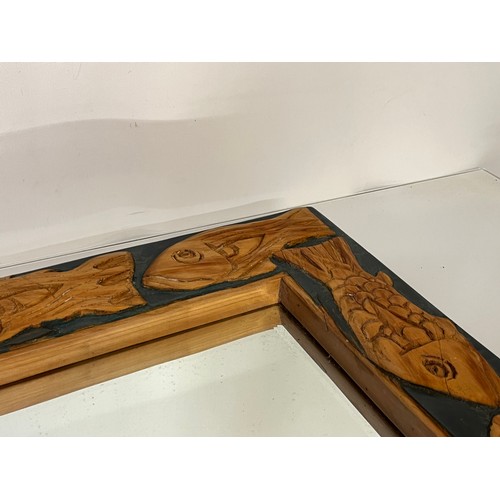 219 - Contempery hand carved wooden framed mirror, decorated with fish. 63 cm x 56 cm x 5 cm.

This lot is... 