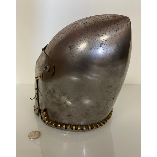 248 - A Medieval design knights helmet with weighted brass trimmings on a steel shell. 26 cm tall x 30 cm ... 