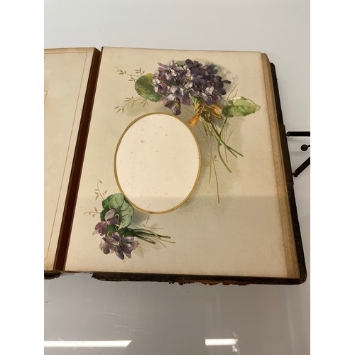 316 - A large early C20th photograph album with pages decorated with botanical illustrations throughout.

... 