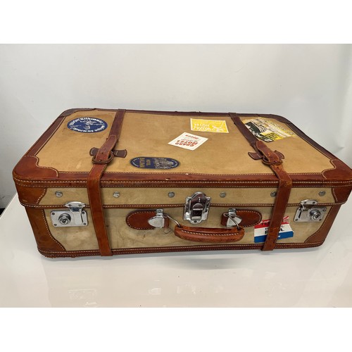 333 - Leather trimmed suitcase, with securing straps and a collection of baggage labels attached. 74 cm x ... 