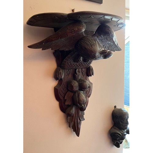 27 - A Black Forest hand carved wall bracket with a carved eagle support, 53 cm wide x 63 cm high x 23 cm... 