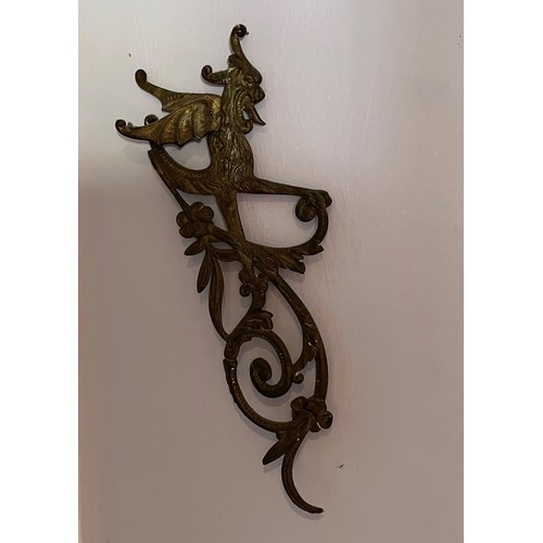 46 - Two cast brass decorative sections featuring winged creatures, each is 30 cm  x 14 cm.

This lot is ... 