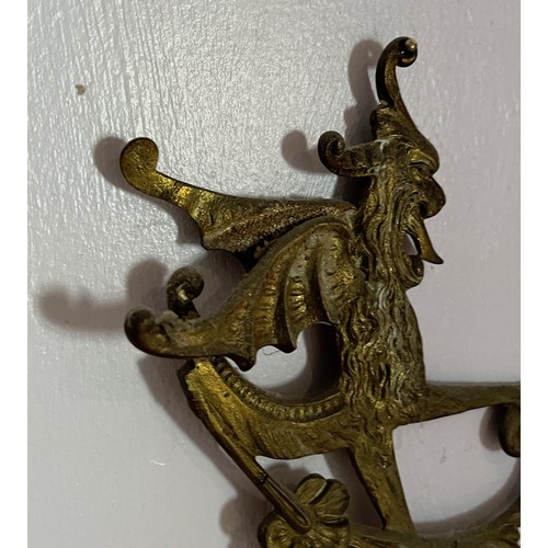 46 - Two cast brass decorative sections featuring winged creatures, each is 30 cm  x 14 cm.

This lot is ... 