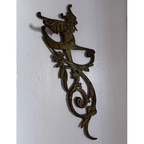 46 - Two cast brass decorative sections featuring winged creatures, each is 30 cm  x 14 cm.

This lot is ... 