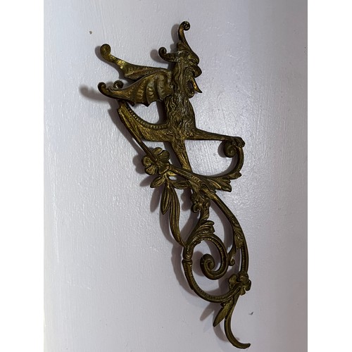 46 - Two cast brass decorative sections featuring winged creatures, each is 30 cm  x 14 cm.

This lot is ... 