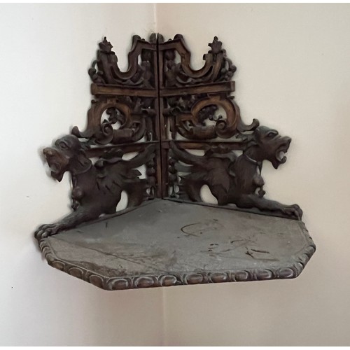 64 - Black forest hand carved corner shelf with winged mythical creatures.

This lot is collection only