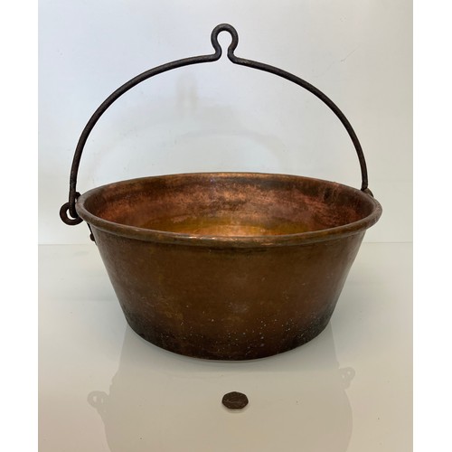 70 - Large copper cooking pan with a wrought iron hanging handle 40 cm dia x 17 cm high.

This lot is ava... 