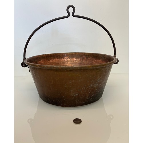 70 - Large copper cooking pan with a wrought iron hanging handle 40 cm dia x 17 cm high.

This lot is ava... 