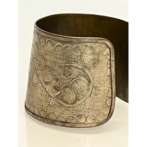 79 - Ethnic Jewellery, an embossed white metal wrist band decorated with botanical designs.

This lot is ... 