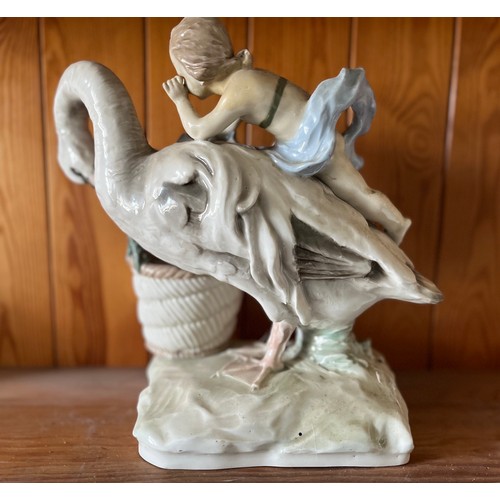 389 - Classical ceramic figure of a child on the back of a swan.

This lot is available for in-house shipp... 