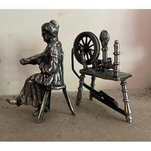 402 - Unmarked white metal cast figure of a woman and her spinning wheel.

This lot is available for in-ho... 