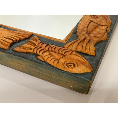 139 - Contempery hand carved wooden framed mirror, decorated with fish. 63 cm x 56 cm x 5 cm.

This lot is... 