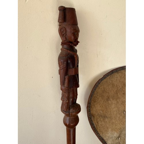 277 - Variety of tribal art pieces, an Armadillo bag, a stick carved with a military figure and a hide fan... 