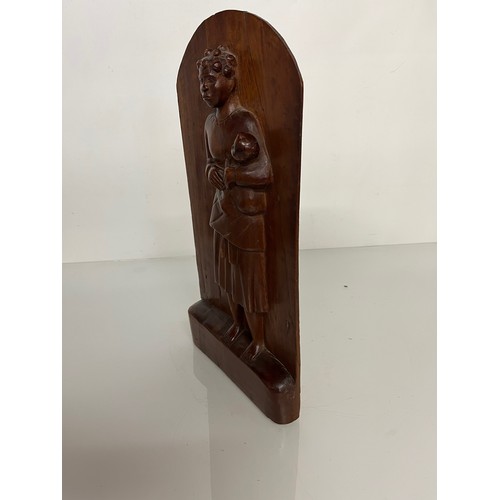 296 - A free standing hand carved wooden panel depicting a black mother holding a young child. 20 cm x 40 ... 