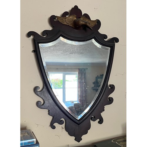 345 - Bevel edged shield shaped wall mirror surmounted with a carved and gilded eagle, 48 cm x 70 cm high.... 