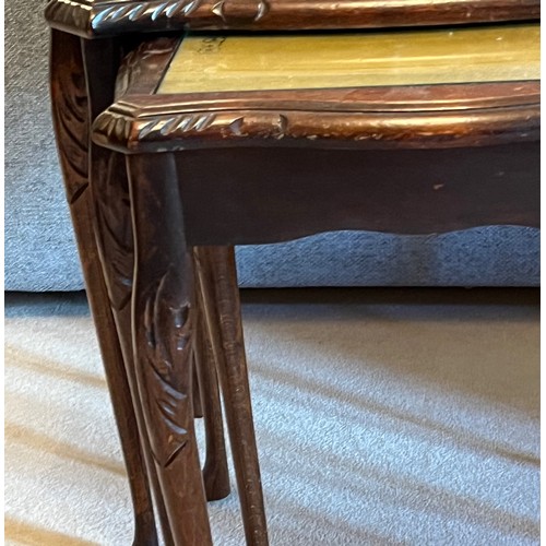 59 - Nest of three tables with embossed leather inserts and carved decoration. 55cm wide, 42 cm wide and ... 