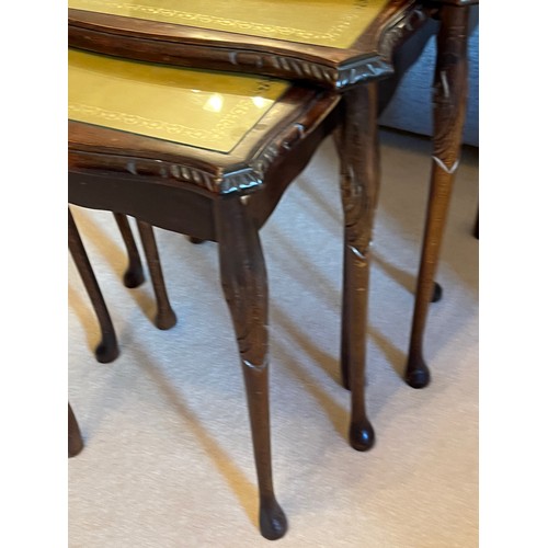 59 - Nest of three tables with embossed leather inserts and carved decoration. 55cm wide, 42 cm wide and ... 