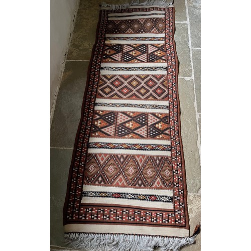 157 - A hand tied floor rug with a geometric design, 2 metres x 70 cm wide.

This lot is available for in-... 