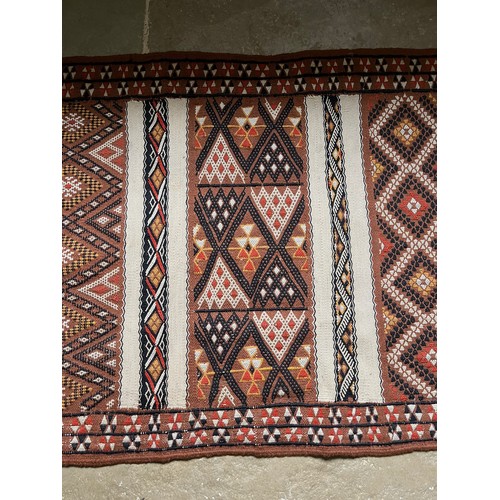 157 - A hand tied floor rug with a geometric design, 2 metres x 70 cm wide.

This lot is available for in-... 