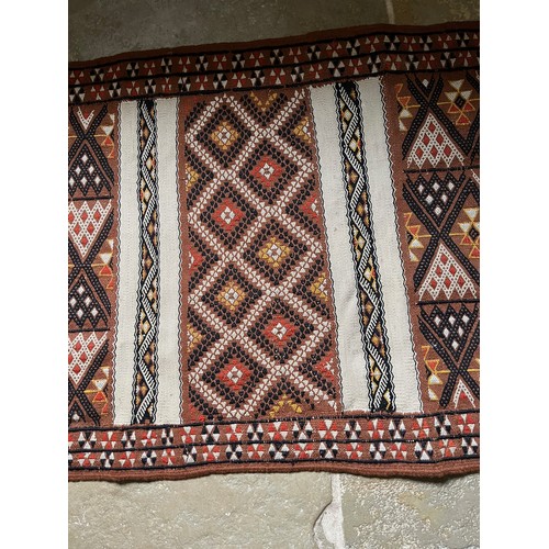 157 - A hand tied floor rug with a geometric design, 2 metres x 70 cm wide.

This lot is available for in-... 