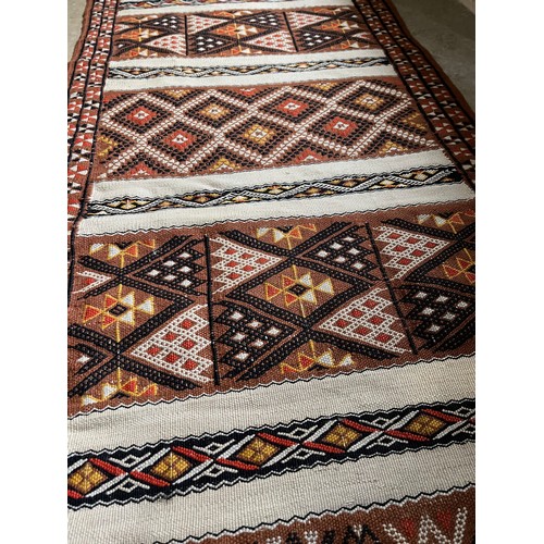 157 - A hand tied floor rug with a geometric design, 2 metres x 70 cm wide.

This lot is available for in-... 