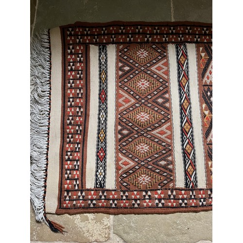 32 - A hand tied floor rug with a geometric design, 2 metres x 70 cm wide.

This lot is available for in-... 