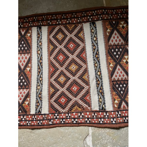 32 - A hand tied floor rug with a geometric design, 2 metres x 70 cm wide.

This lot is available for in-... 