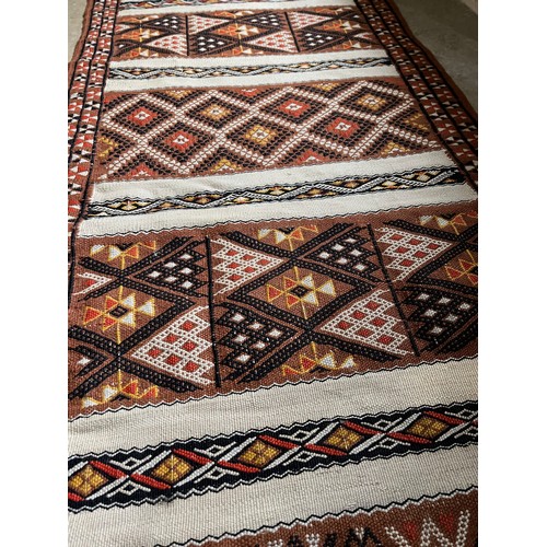 32 - A hand tied floor rug with a geometric design, 2 metres x 70 cm wide.

This lot is available for in-... 