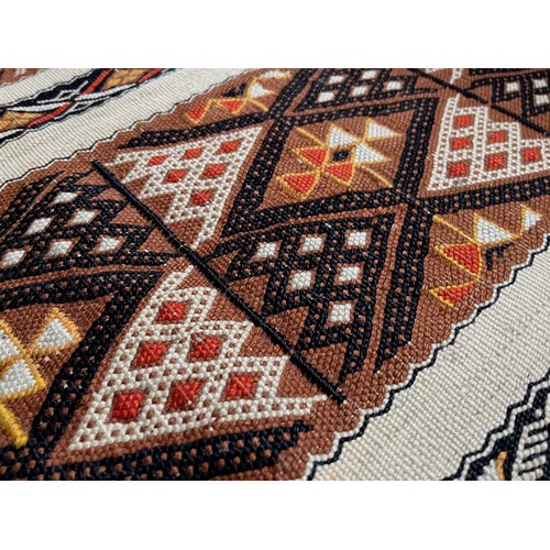 32 - A hand tied floor rug with a geometric design, 2 metres x 70 cm wide.

This lot is available for in-... 