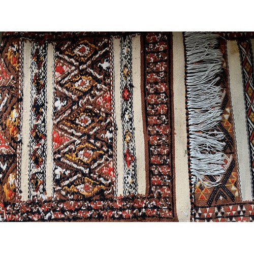 32 - A hand tied floor rug with a geometric design, 2 metres x 70 cm wide.

This lot is available for in-... 