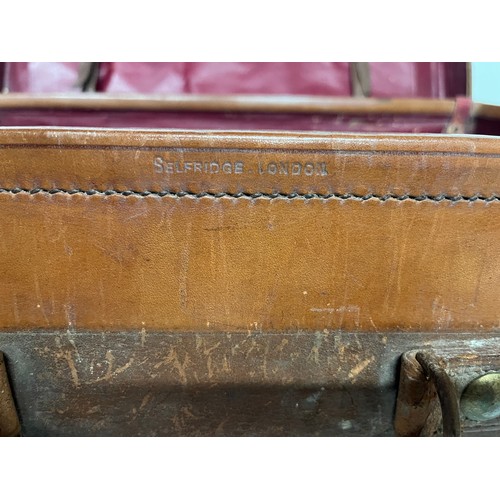 383 - Early C20th luggage, a leather suitcase marked for Selfridge London, with travel label illustrated w... 