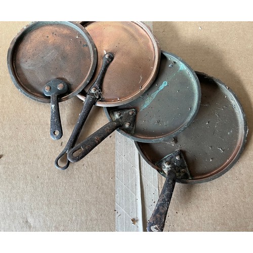 509 - A set of four graduated copper pan lids with cast handles.
Overall diameters of the lids are.

19cm ... 