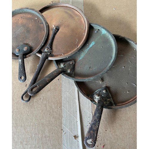 509 - A set of four graduated copper pan lids with cast handles.
Overall diameters of the lids are.

19cm ... 