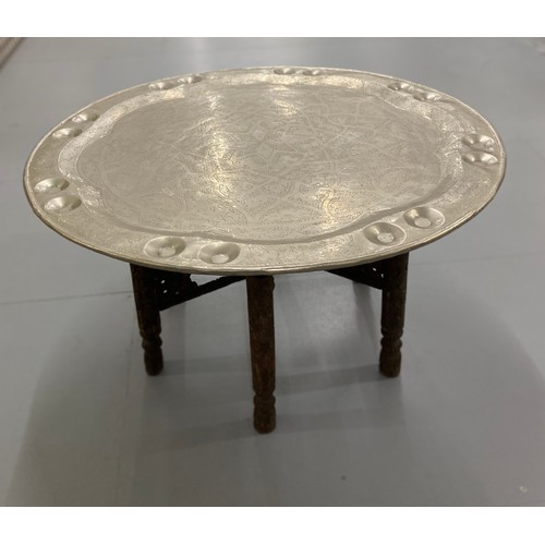 370 - Furniture, North African folding table with 76 cm diameter top with embobbed and carved designs.