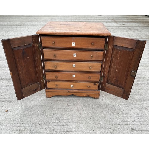 93 - Pine collectors cabinet five drawer sections behind two doors. 45 x 39 cm x 52 cm high.

This lot is... 