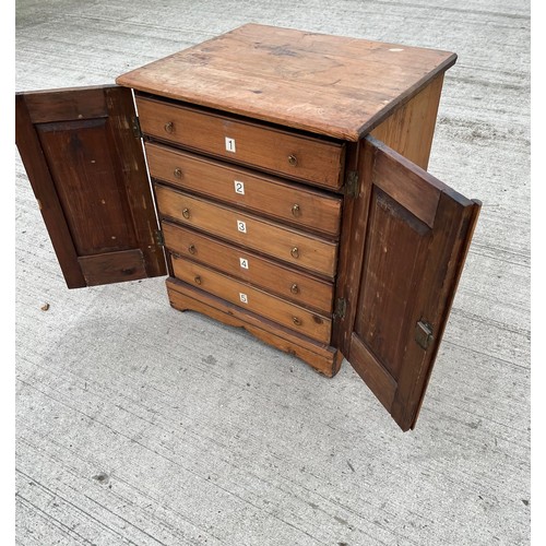 93 - Pine collectors cabinet five drawer sections behind two doors. 45 x 39 cm x 52 cm high.

This lot is... 