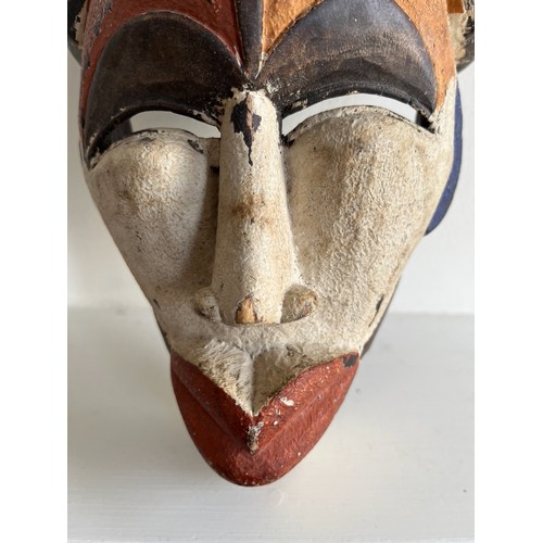 268 - Ethnic tribal art, a carved African mask with painted decoration.

This lot is available for in-hous... 