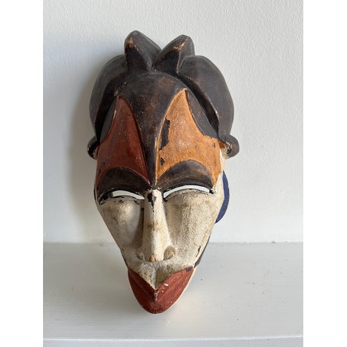 268 - Ethnic tribal art, a carved African mask with painted decoration.

This lot is available for in-hous... 