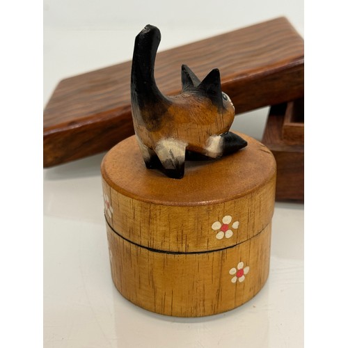 163 - Treen boxes, a circular box with a hand carved cat to the lid, 10 cm tall and another.

This lot is ... 