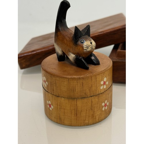 163 - Treen boxes, a circular box with a hand carved cat to the lid, 10 cm tall and another.

This lot is ... 